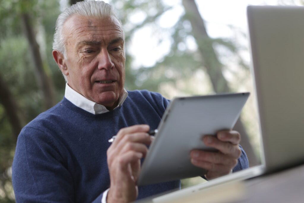 An older man using a tablet computer.
